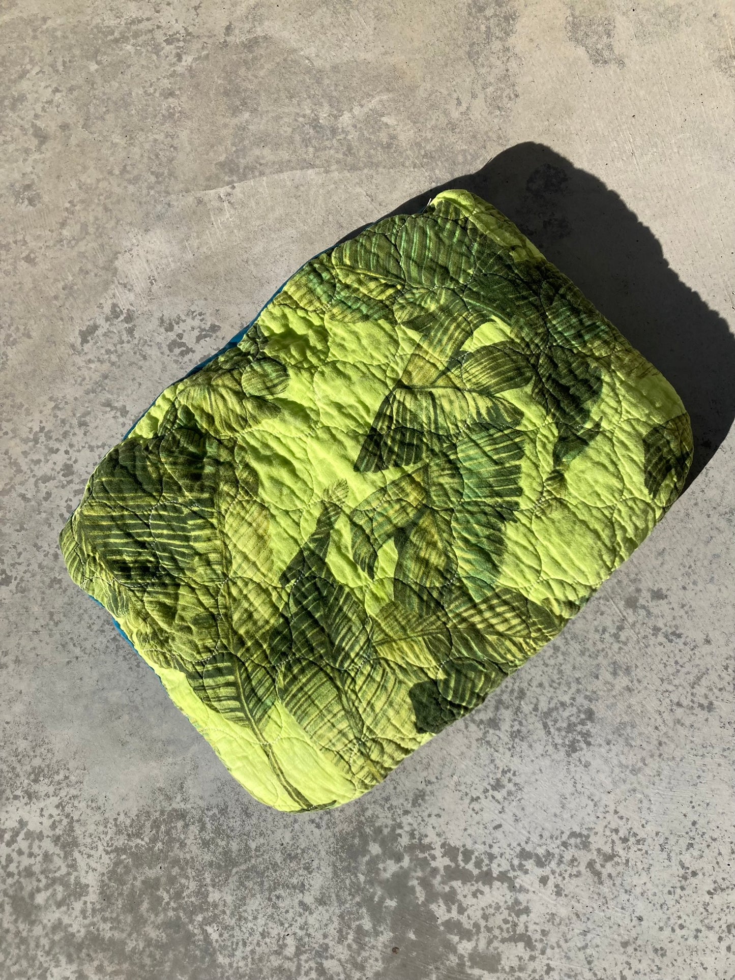 Hand-dyed lime green pet pillow with a tropical leaf print.