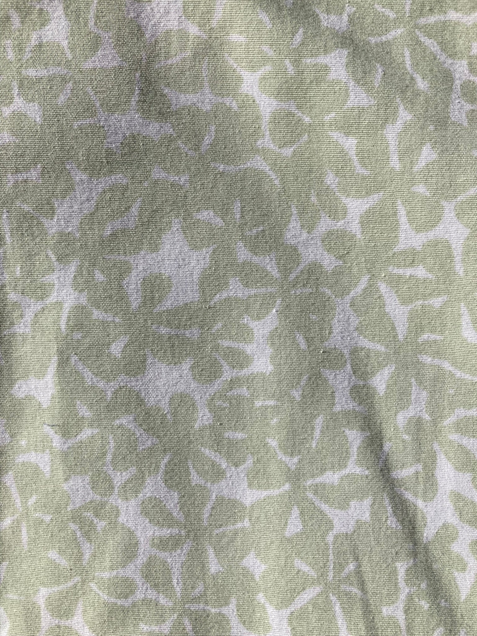 The backing fabric for the robin's egg pet pillow, which has a light green leaf/flower pattern over a very light green/white background.