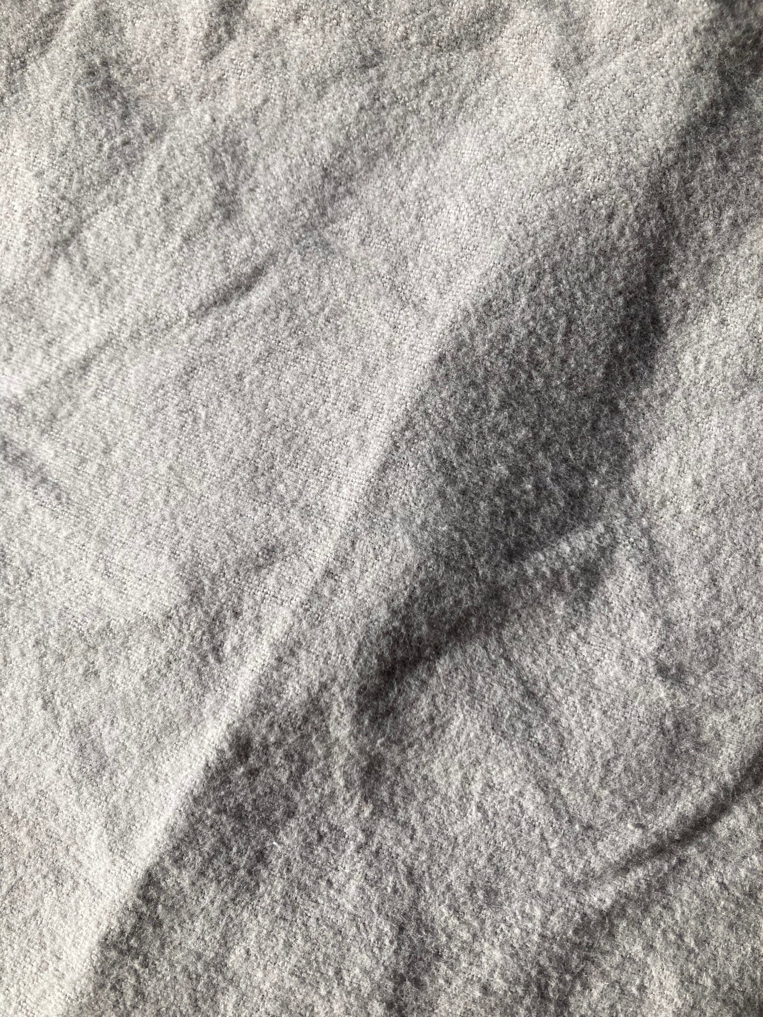 Backing fabric of the grey velvet pet pillow, which is a light grey cotton flannel.